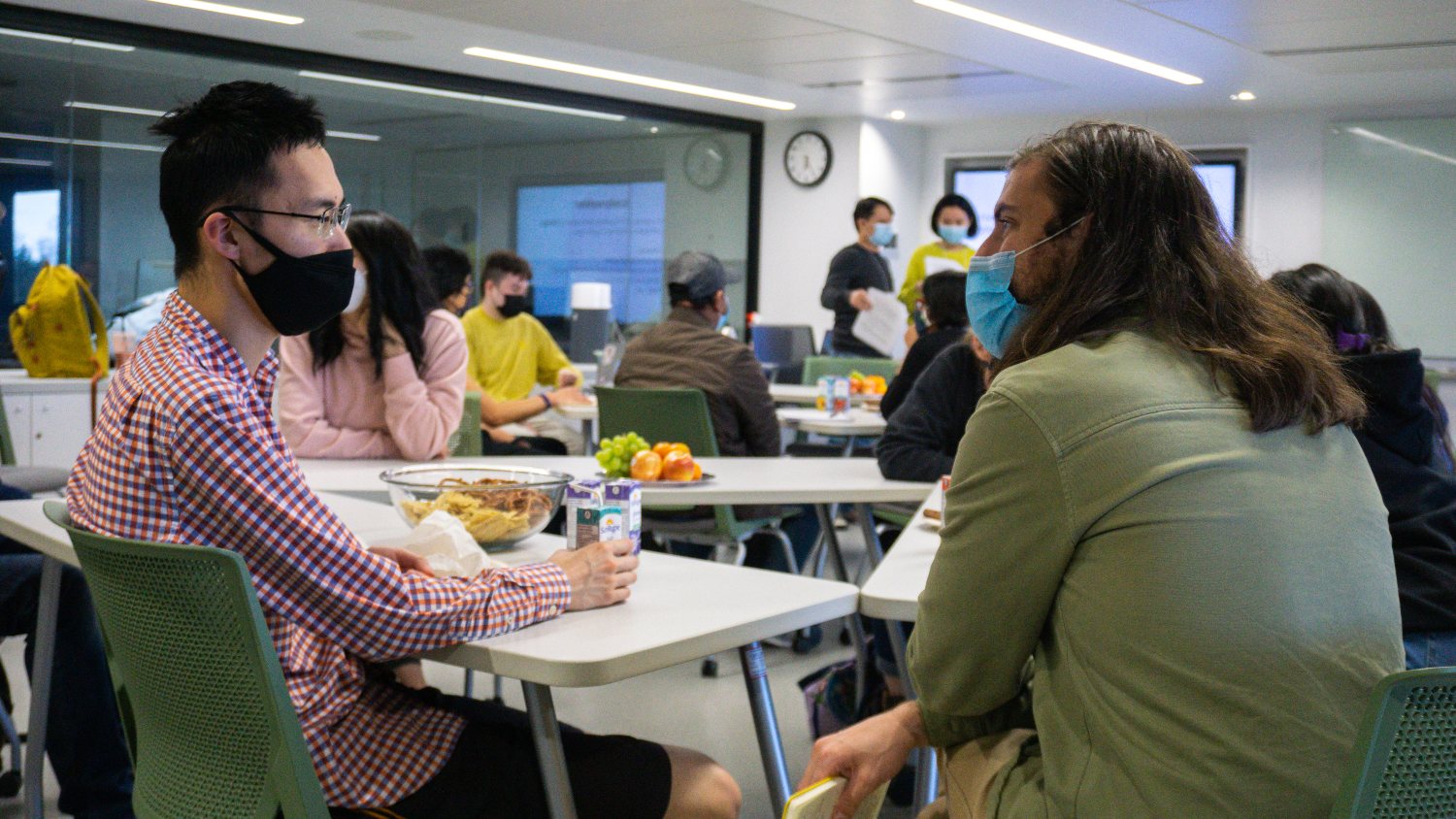 Two people converse in a classroom.