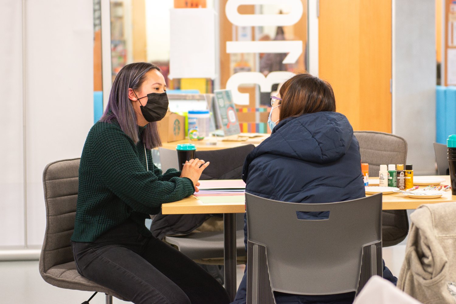 Two people sit and chat in the Embark Studio.